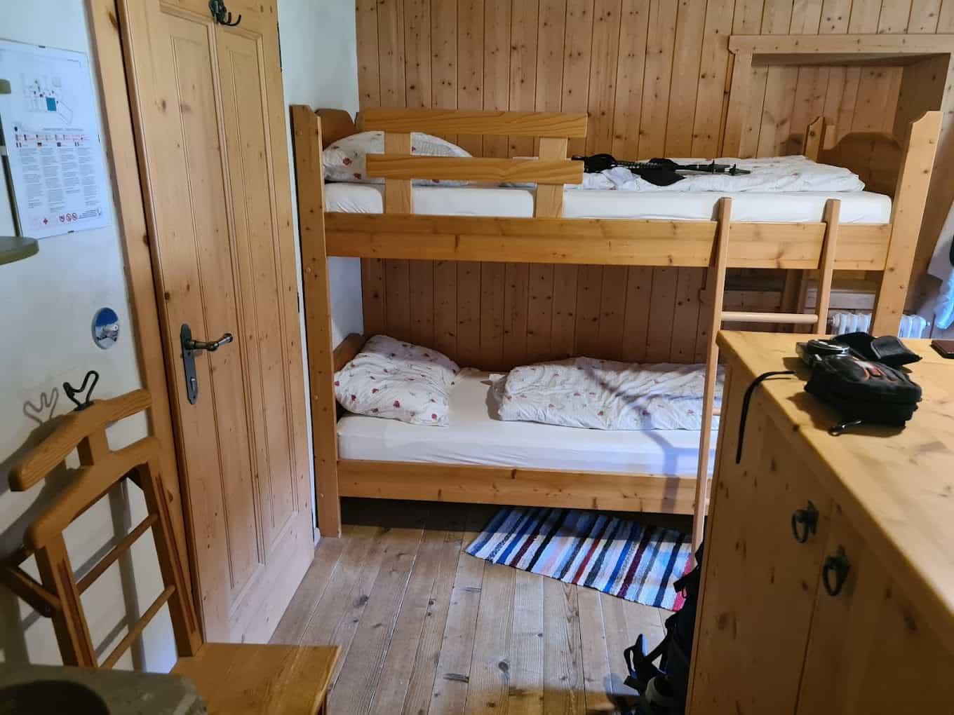 Wooden bunk beds in a room with wood paneling, likely a mountain refuge.