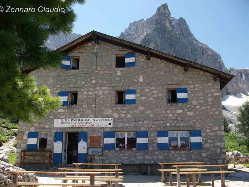 Rifugio Vandelli stone mountain hut with blue shutters below jagged Dolomite peaks