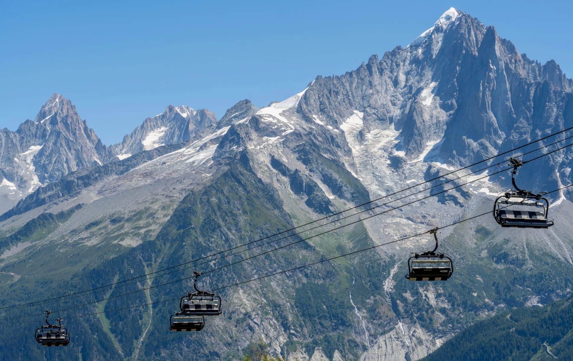 Cable cars below the Aiguilles mountain peaks with snow