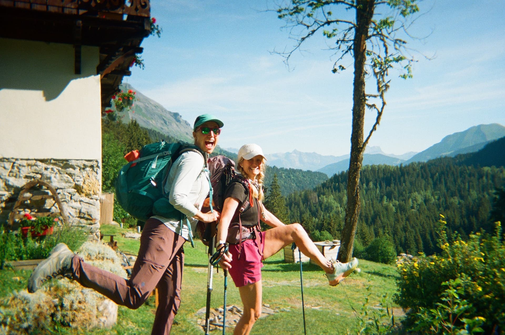 Hikers with backpacks jumping for joy in front of mountain landscape