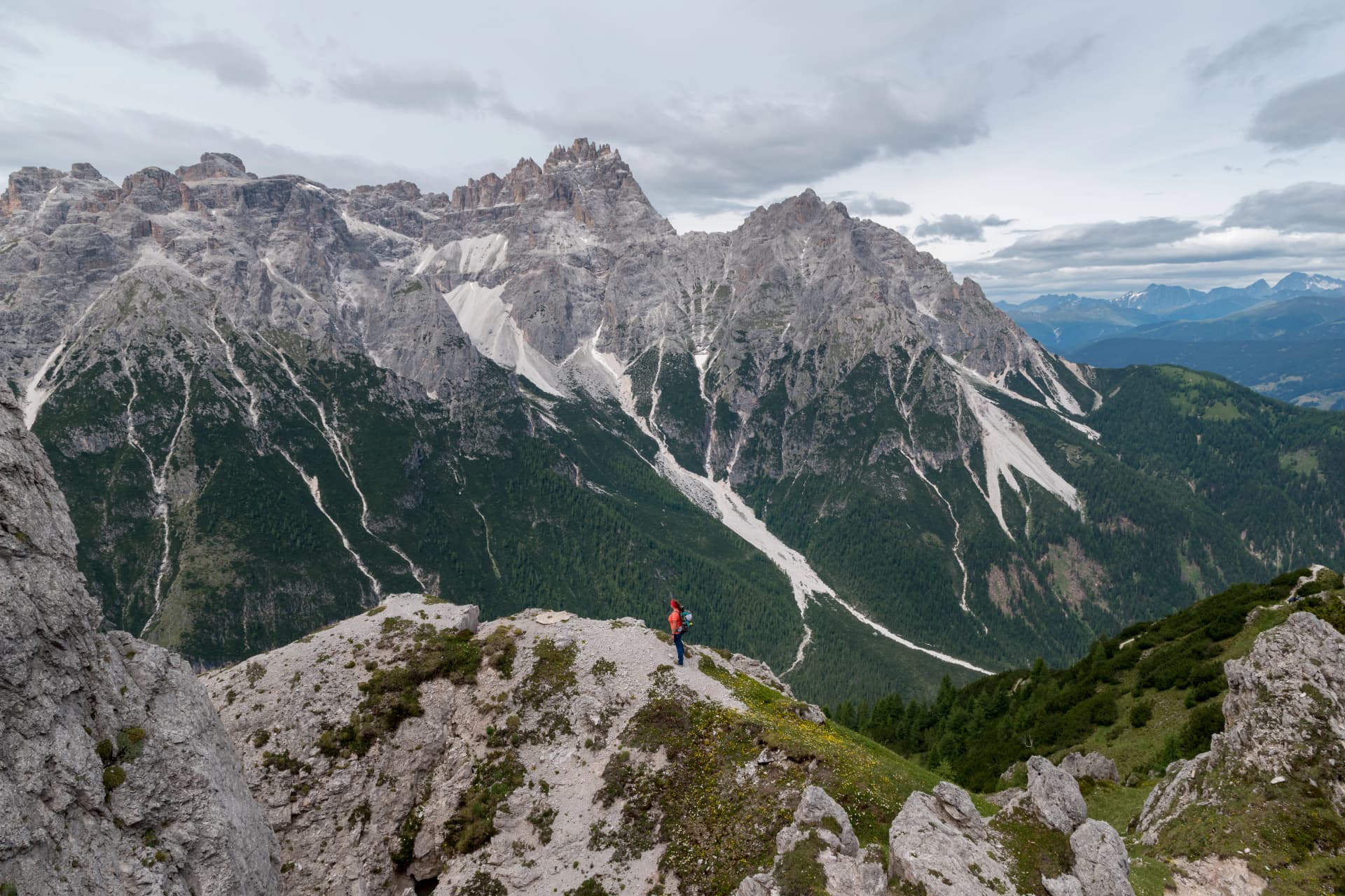 View into the valley Val Fiscalina in Sesto with an mountaineer women and the beautiful rock formations of the UNESCO World Heritage of the Dolomites mountains in the background.