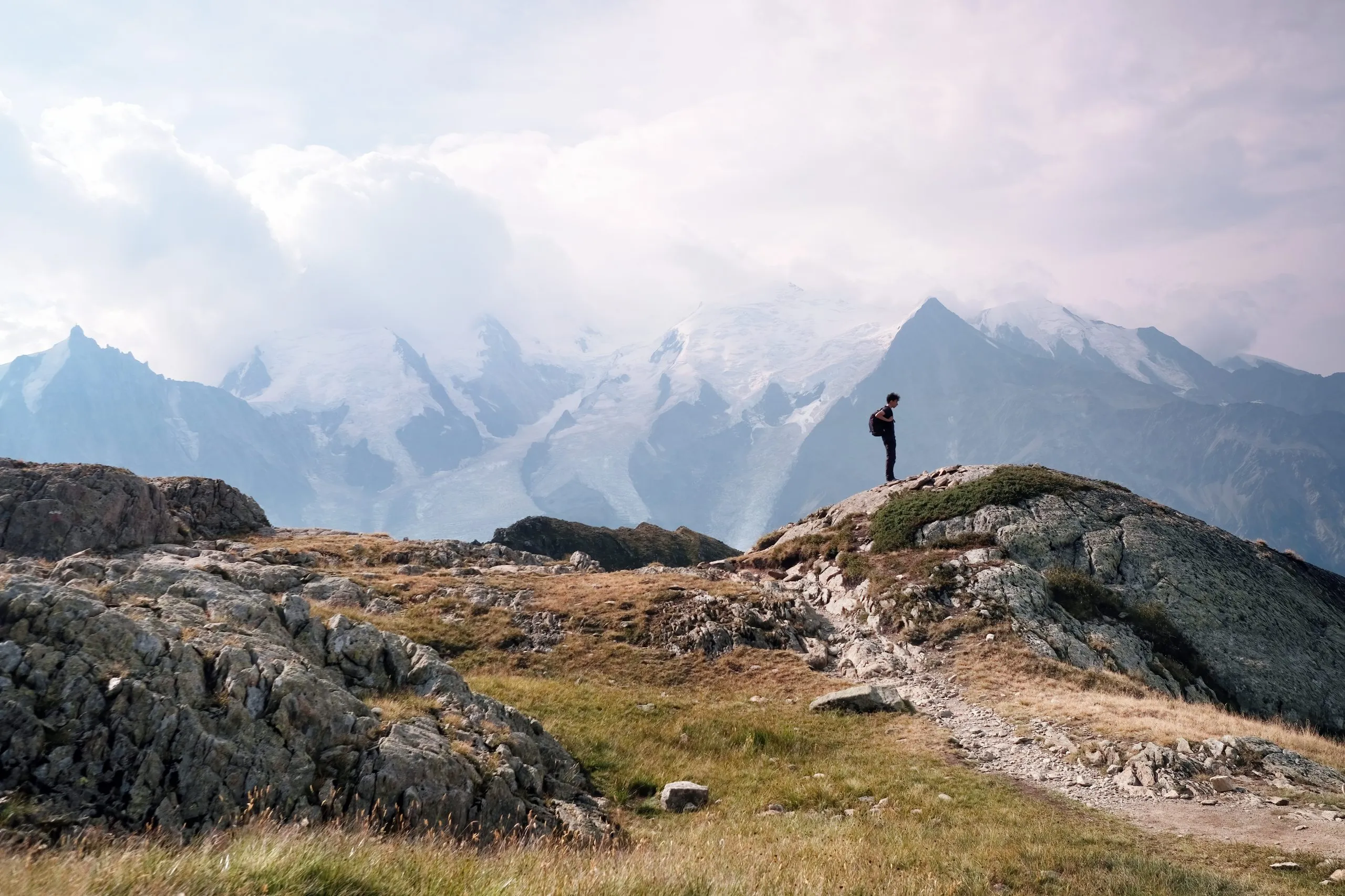 Scenic view of Mont Blanc massif seen from Le Brevent, Aiguille Rouges nature reserve and part of Tour de Mont Blanc, Chamonic, French Alps, Haute Savoie, France. Hiker on the route.